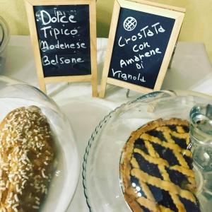 a table topped with a plate of food and signs at Hotel Cinzia in Savignano sul Panaro +20 photos