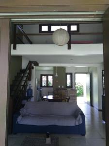 a room with a bed and a table and stairs at Casa Caribe in Garopaba