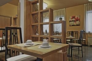 a kitchen with a wooden table and chairs at Hotel Romanisio in Fossano