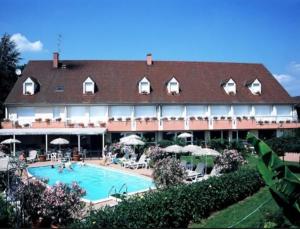 a large hotel with a swimming pool in front of it at Les Songes de Buxy in Buxy