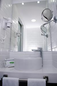 a white bathroom with a sink and a mirror at Hotel Ereza Mar - Adults Only in Caleta De Fuste