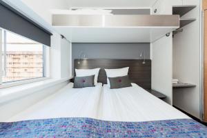 - une chambre avec un grand lit blanc et 2 oreillers dans l'établissement Cabinn Scandinavia, à Copenhague