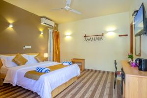 a bedroom with a bed and a flat screen tv at Paguro Villa in Ukulhas