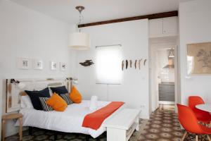 1 dormitorio con 1 cama con almohadas de color naranja y azul en FLORIT FLATS - Ático Oasis de Ruzafa, en Valencia