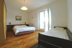 a bedroom with two beds and a large window at Beach Apartment Viktor 2 in Postira