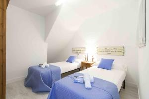 2 camas en una habitación de color azul y blanco en The Rentals Collection | Coeur, en San Sebastián