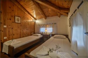 2 camas en una habitación con paredes de madera en Anna Apartments, en Lithakia