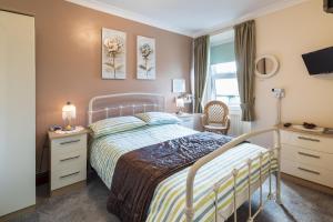 1 dormitorio con cama, escritorio y ventana en DUNVEGAN, en Windermere