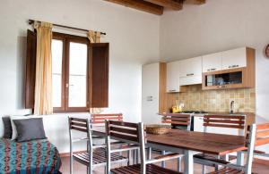 a kitchen and dining room with a wooden table and chairs at Punta del Cane in Fontane Bianche