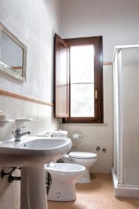 a bathroom with a sink and a toilet and a window at Punta del Cane in Fontane Bianche