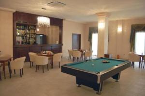 a room with a pool table and tables and chairs at Club Insieme Grand Resort in Potlogi