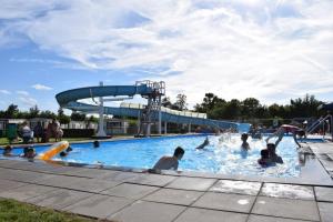 un grupo de personas en una piscina con un tobogán de agua en Het ScheldeChalet, en Baarland