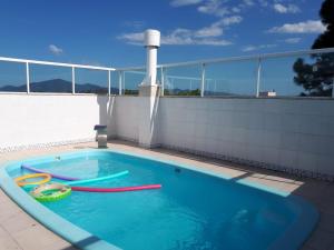 a swimming pool with two inflatable toys in it at Pousada Hospedagem Palhoça in Palhoça