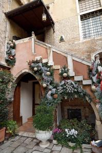une entrée à un bâtiment avec des plantes et des fleurs dans l'établissement Palazzo Odoni, à Venise