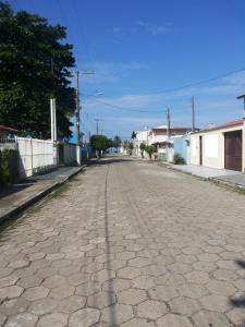 an empty street in a town with a cobblestone road at Casa em Itanhaém in Itanhaém