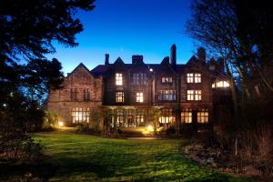 an old house with lights on a lawn at night at Jesmond Dene House in Newcastle upon Tyne