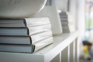a stack of books sitting on a white shelf at Hotel Spot Varazze in Varazze