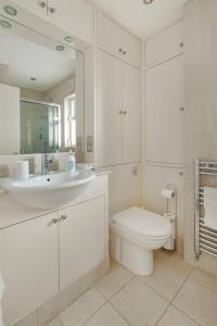 a white bathroom with a sink and a toilet at Fulham B&B in London