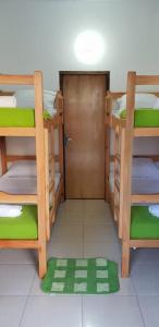a room with three bunk beds and a door at Helecho's Hostal in Encarnaci&oacute;n