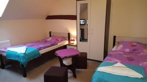 Habitación con 2 camas, silla y espejo. en Agroturystyka Struzka, en Strużka