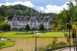 a large building with a river in front of it at Casa do Sol Hotel in Petrópolis