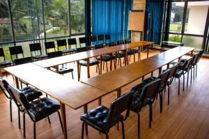 a row of tables and chairs in a room with windows at Casa do Sol Hotel in Petrópolis +31 photos