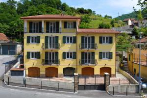 uma casa amarela com uma cerca em frente em Alle Porte di Genova em Sant'Olcese