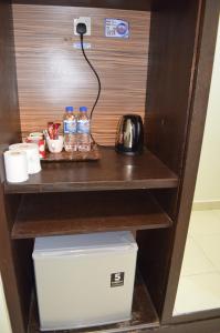 a desk with bottles of water and a kettle at Gold Coast Morib Ain Studio in Kampong Tanjong Pechah