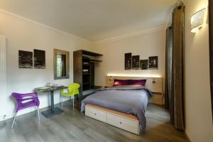 a bedroom with a bed and a table and a mirror at Les Balcons du Rohan in Saverne