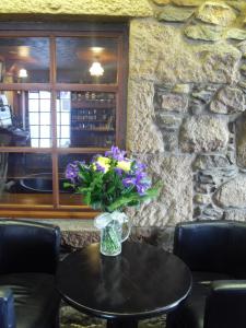 a vase with purple flowers sitting on a table at The Neuk in Portlethen