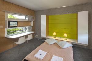 a hotel room with a bed, desk, and television at Lausanne Youth Hostel Jeunotel in Lausanne