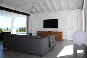 a living room with a couch and a flat screen tv at The Pearl in Orient Bay