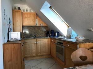 a kitchen with wooden cabinets and a laptop on the counter at Urseetalblick in Lenzkirch