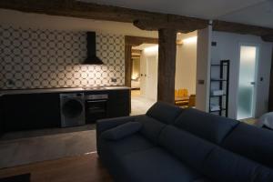 a living room with a blue couch and a kitchen at Loft 7calles, Casco Viejo. Bio in Bilbao