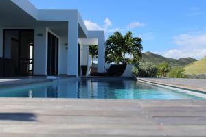 a swimming pool in front of a villa at The Pearl in Orient Bay