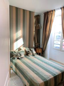 a bedroom with a large bed with a striped wall at Hyper Centre Place Massena in Nice