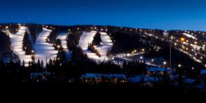 a ski slope with snow and trees at night at Hotel St-Sauveur in Saint-Sauveur-des-Monts
