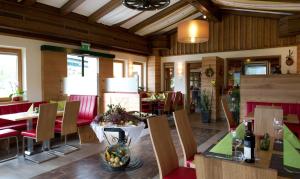 ein Restaurant mit roten Stühlen und einem Tisch mit einer Schale Obst in der Unterkunft Sportpension Goldegg in Goldegg
