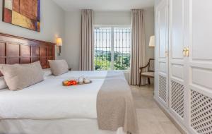 a bedroom with a large bed and a large window at Ona Alanda Club Marbella in Marbella