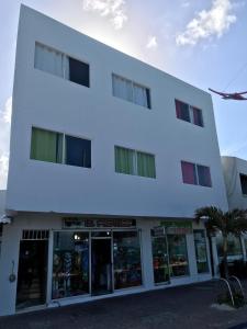 un edificio blanco con una tienda frente con ventanas en Alojamiento View Jhony Cay, en San Andrés