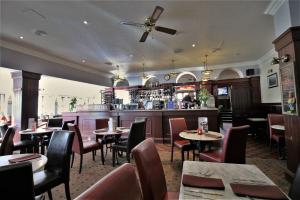 a restaurant with tables and chairs and a bar at Fairway Hotel in Bathgate