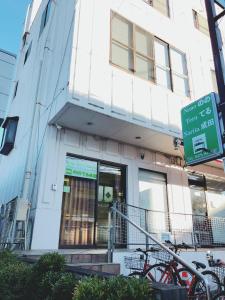 a building with a green sign in front of it at Nono teru Narita in Narita
