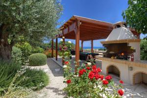 a outdoor oven in a garden with red roses at Villa Pashiana in Polis Chrysochous