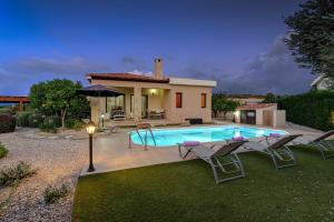 a villa with a swimming pool in front of a house at Villa Pashiana in Polis Chrysochous