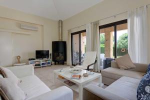 a living room with two couches and a table at Villa Pashiana in Polis Chrysochous