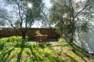 una mesa y sillas en un jardín con árboles en Casa de los Olivos, chimenea con horno 2 Hab 4 Pers mas 1 Max, en Puerto de la Laja