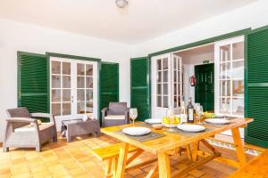une salle à manger avec des murs verts et une table en bois dans l'établissement Casa Maria, à Cala Galdana