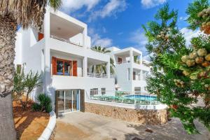 a white villa with a swimming pool and a palm tree at Villa Pou Uno in Santanyi
