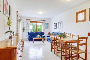 a living room with a table and a blue couch at Villa Pou Uno in Santanyi