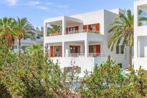 a white house with palm trees in front of it at Villa Pou Uno in Santanyi